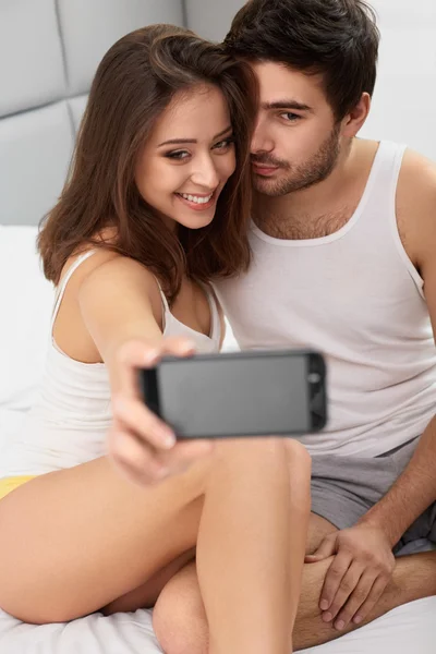 Odběr Selfie pár v posteli — Stock fotografie