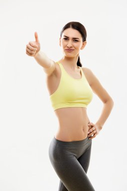 başparmak gösterilen mutlu fitness genç kadın.