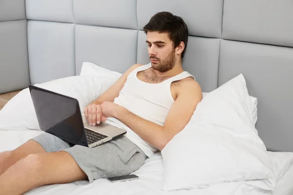 Orang yang bekerja dengan komputer di tempat tidur. — Stok Foto