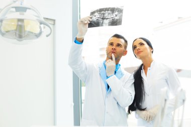 Diş hekimi ve kadın Yardımcısı diş röntgen görüntü görüşüyorlar
