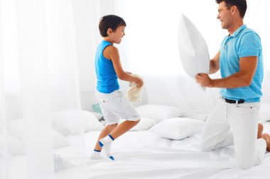 Father and son having fun. Pillow fight