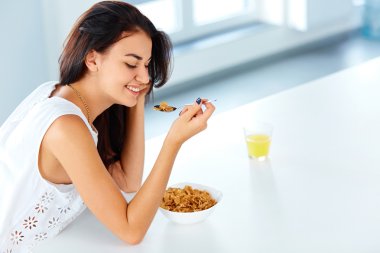 kadın bir kaşık ve bir kase mısır gevreği aşağı bakıyor