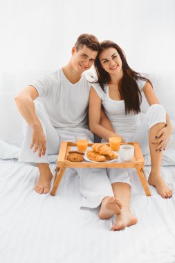 Portrait of man and woman with breakfast in bed