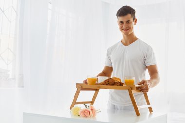 Young man with  breakfast in bed
