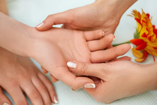 Massagem de mãos. Bela loira recebe tratamento de spa no salão . — Fotografia de Stock
