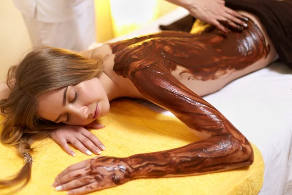 水疗中心的女人。年轻女子在美容院获取巧克力身体掩码 — 图库照片