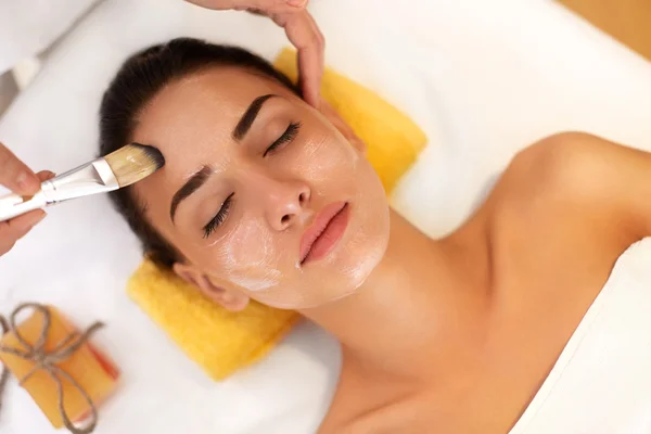 Tratamiento facial. Mujer en salón de belleza consigue máscara marina —  Fotos de Stock