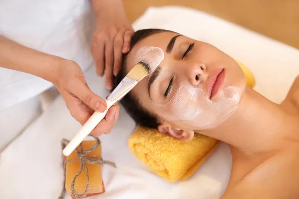 Tratamiento facial. Mujer en salón de belleza consigue máscara marina —  Fotos de Stock