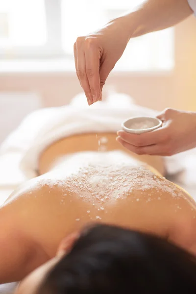 Mujer Spa. Morena consiguiendo una sal exfoliante tratamiento de belleza en el —  Fotos de Stock