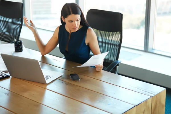 Retrato de una mujer de negocios confusa que trabaja con papeles en — Foto de Stock