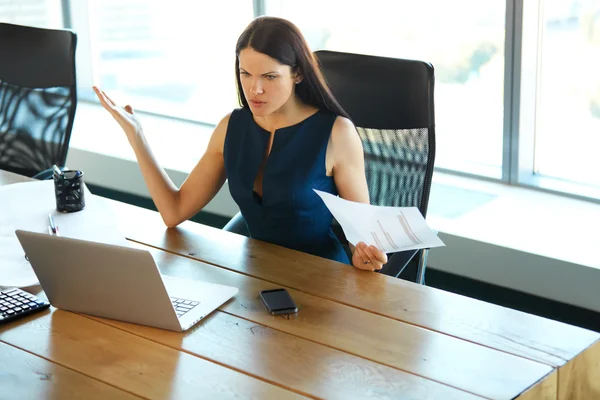 Retrato de una mujer de negocios confusa que trabaja con papeles en —  Fotos de Stock