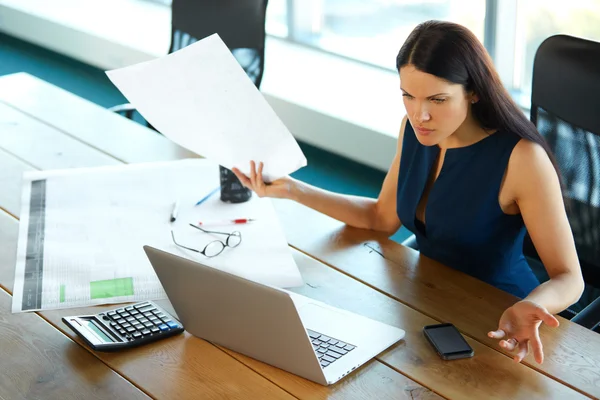 Portrait d'une femme d'affaires confus qui travaille avec des papiers dans — Photo