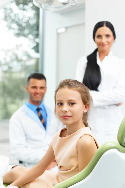 Tandarts Team en gelukkig jonge patiënt op tandheelkundige kliniek — Stockfoto