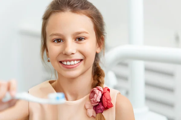 Liten flicka håller Teeh borste. Glad tjej borsta hennes tänder — Stockfoto