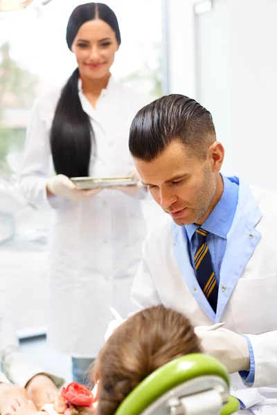 Tandläkare med assistenten undersökande lite tjejer tänder i Denti — Stockfoto