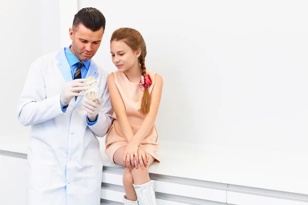 Dentista mostrando a una chica cómo cepillarse los dientes . —  Fotos de Stock