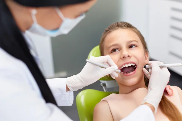 Sprawdzanie zębów w gabinecie stomatologicznym. Badając dziewczyny zębów dentysta — Zdjęcie stockowe
