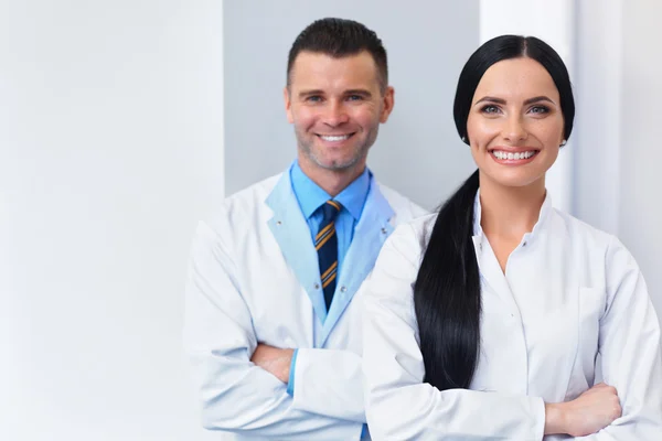 Diş Kliniği, dişçi takım. Kendi iş yerinde iki gülümseyen doktor — Stok fotoğraf