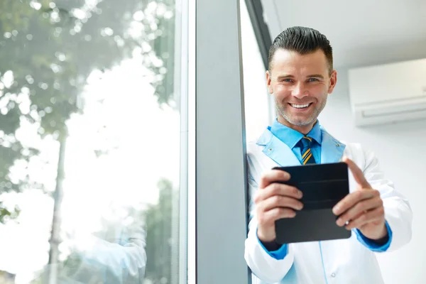 Médico dentista tira foto usando seu smartphone . — Fotografia de Stock