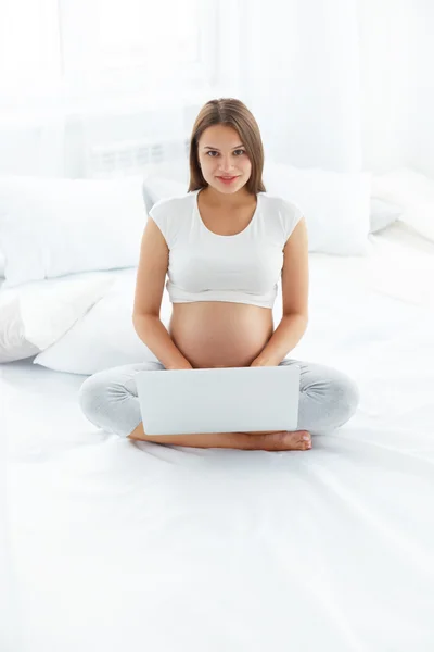 Donna incinta che utilizza il computer portatile — Foto Stock