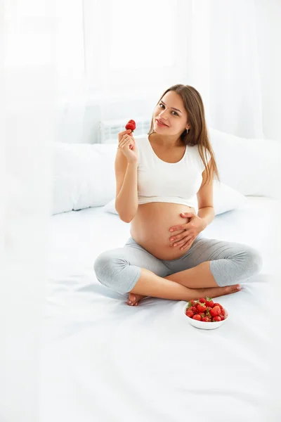 Femme enceinte mangeant des fraises à la maison. Concept d'alimentation saine . — Photo