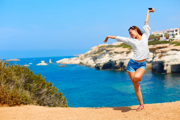 Woman with arms raised up near the sea — 스톡 사진