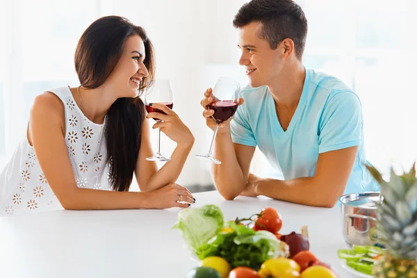 Casal vegetariano bebendo vinho tinto na cozinha — Fotografia de Stock