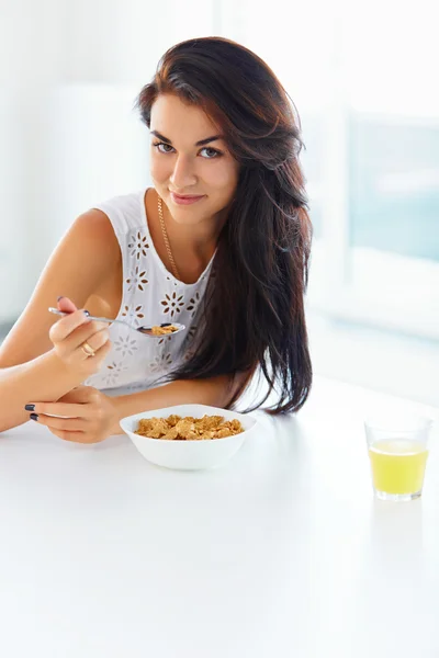Girl eating cereal and smiling at the camera — Stock fotografie