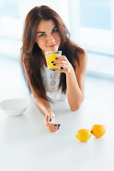 Chica bebiendo jugo de naranja y sonriendo a la cámara. Jui cítrico — Foto de Stock