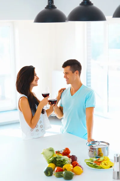 Пара насолоджується вином під час роботи на кухні — стокове фото