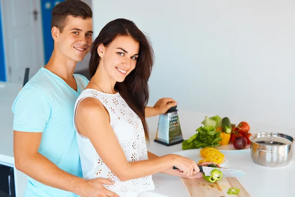 Couple preparing dinner and smiling at the camera. — Stock Photo, Image