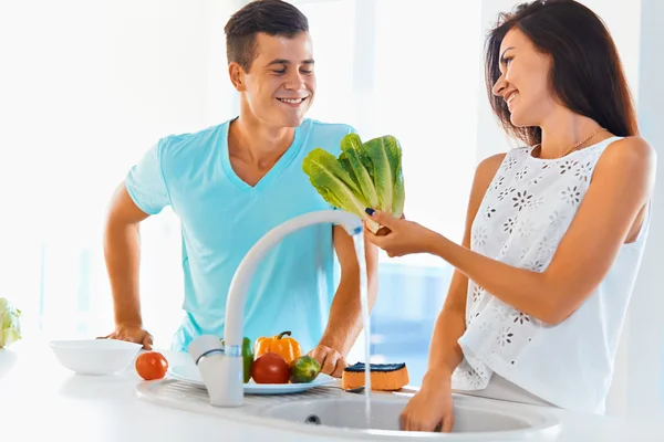 Couple washing organic vegetables together — Stockfoto