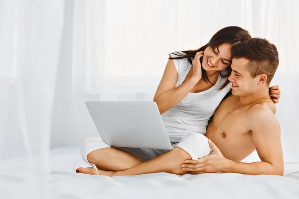 Hombre y mujer usando el ordenador portátil en casa — Foto de Stock