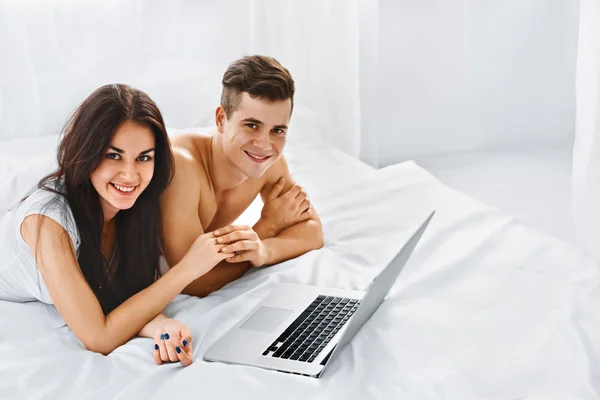 Couple with laptop on bed — Stock fotografie