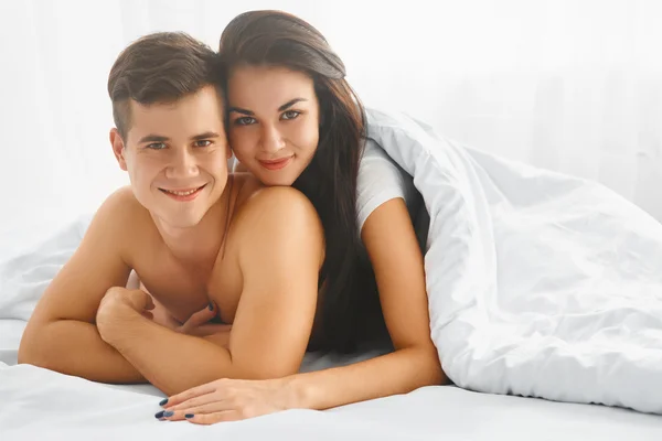 Pareja feliz en la cama — Foto de Stock