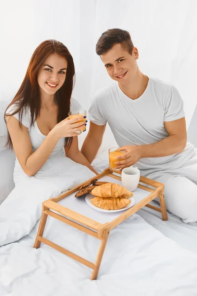 Homme et femme prenant le petit déjeuner au lit — Photo