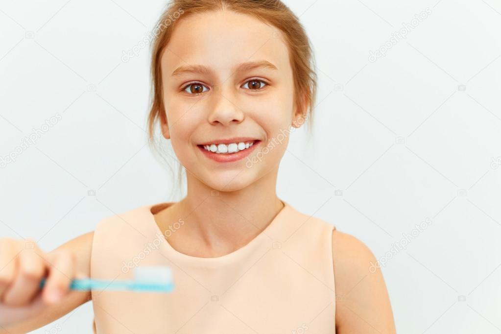 Little girl holding Teeh Brush.  Happy girl brushing her teeth