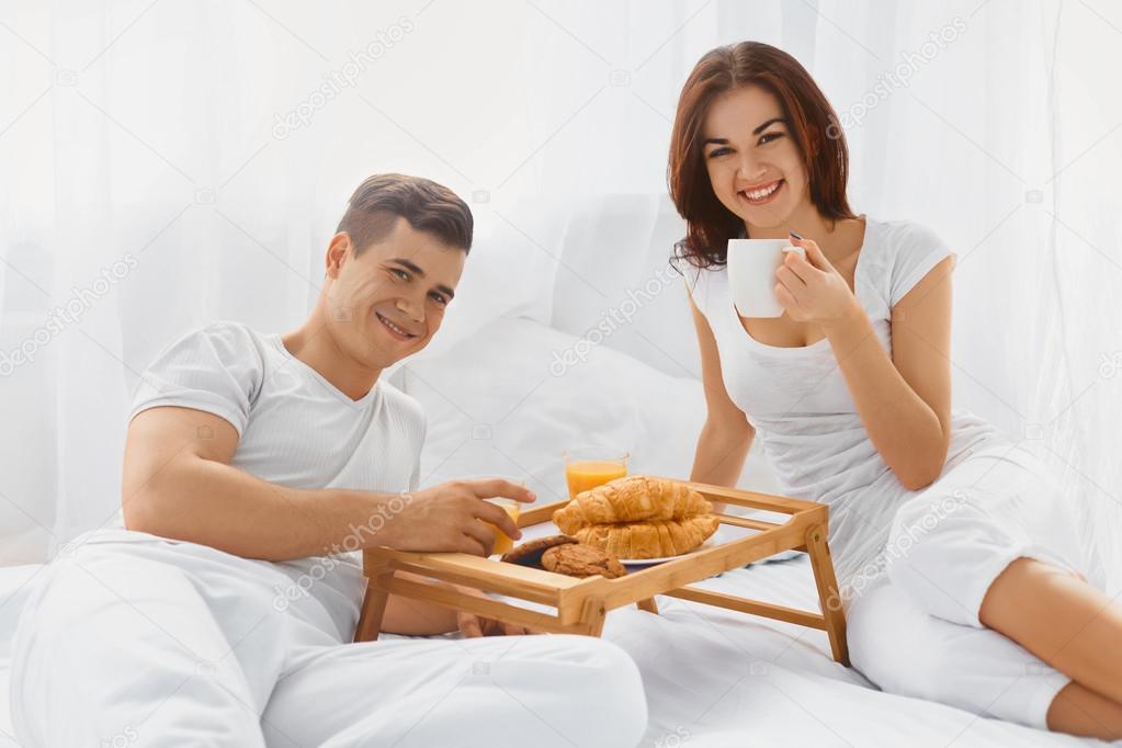 Portrait of couple enjoying breakfast in bed