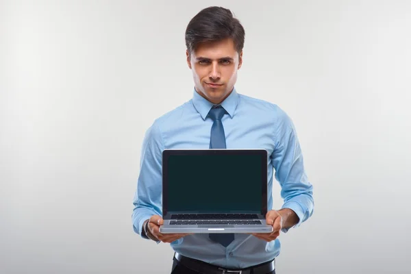 Homme d'affaires tenant un ordinateur portable sur un fond blanc — Photo