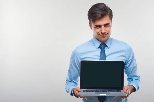 Hombre de negocios sosteniendo un ordenador portátil sobre un fondo blanco —  Fotos de Stock