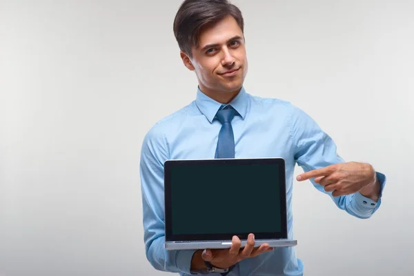 Hombre de negocios sosteniendo un ordenador portátil sobre un fondo blanco —  Fotos de Stock