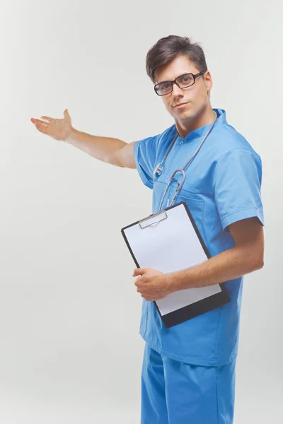 Doutor mostrando um espaço de cópia contra fundo branco . — Fotografia de Stock