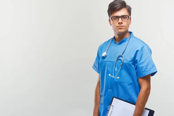 Doktor s stetoskop kolem jeho krku proti šedé pozadí — Stock fotografie