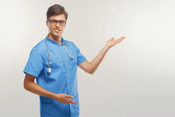 Doutor mostrando um espaço de cópia contra fundo branco . — Fotografia de Stock