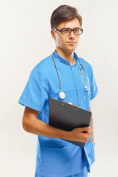 Lekarz z stetoskop wokół jego szyi przed szary tło — Zdjęcie stockowe