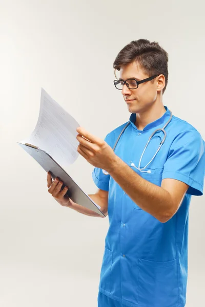 Doctor mostrando portapapeles sobre fondo blanco —  Fotos de Stock