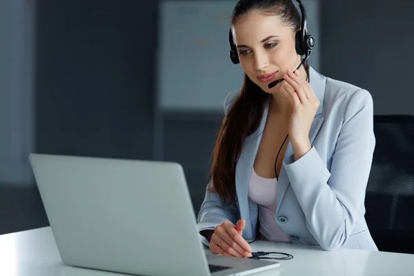 Operadora de Call Center sentada na frente de seu computador — Fotografia de Stock