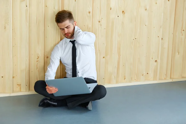 Empresario cansado sentado en el piso de su oficina. Trabajo duro y — Foto de Stock