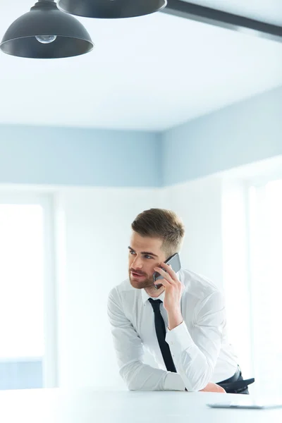 Junger Geschäftsmann telefoniert im modernen Büro — Stockfoto