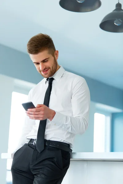 Geschäftsmann liest etwas auf dem Bildschirm seines Handys — Stockfoto